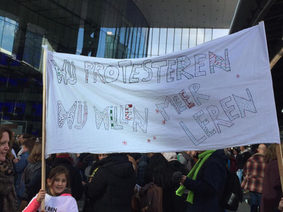 Kinderen met spandoek "Wij protesteren, wij willen meer leren"