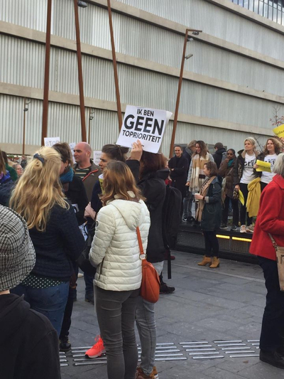 Verzamelde mensen met spandoek "ik ben GEEN topprioriteit"