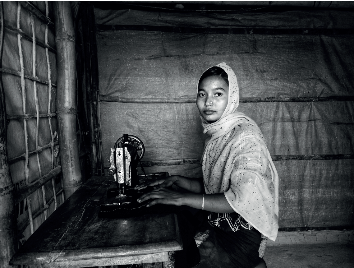 foto in bianco e nero di una donna velata dietro una macchina da cucire vecchio stile